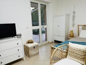 锡尔维玛丽娜Beach apartments Spiaggia Nascosta的一间卧室配有一张床,梳妆台上配有电视