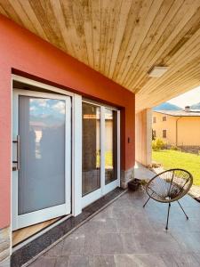 Berbenno di ValtellinaTellure apartments with breakfast的庭院设有滑动玻璃门和长凳