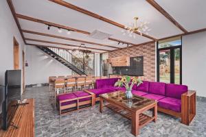 巴位Villa de Montana的客厅配有紫色沙发和桌子