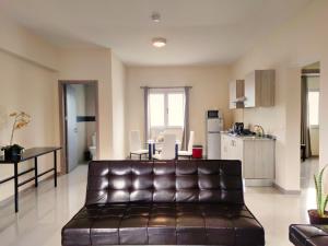 普拉亚Praia Capital Residence Aparthotel的一间带真皮沙发的客厅和一间厨房
