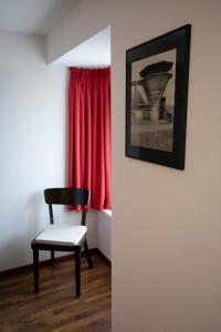 HerznachGasthof Löwen Herznach的红色窗帘的房间的椅子