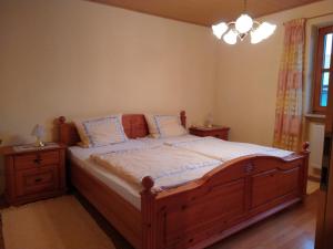马夸特施泰因Ferienwohnung Achental的一间卧室配有一张带2个床头柜的大型木床