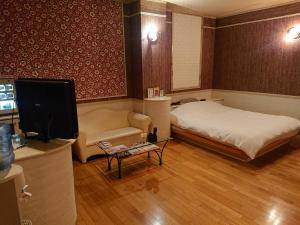Shimotsukeスタイリッシュ栃木　大人専用的客房设有床、沙发和电视。