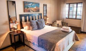 LephalaleFour Seasons Guesthouses的一间卧室配有一张大床和一把椅子