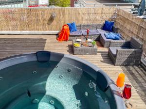 里加Skyhouse Riga Lux Penthouse & SPA的后院的热水浴池,配有桌子和沙发