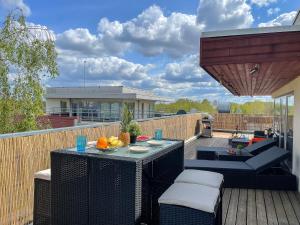 里加Skyhouse Riga Lux Penthouse & SPA的露台设有桌椅