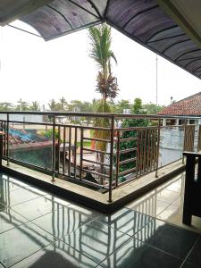 庞岸达兰Hotel Abad Baru 1的阳台享有棕榈树和水景。