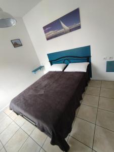 讷莱米讷Résidence Les Hauts de France的一间卧室配有一张大床和蓝色床头板