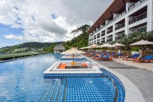 芭东海滩Andamantra Resort and Villa Phuket - SHA Extra Plus的游泳池,带椅子和遮阳伞
