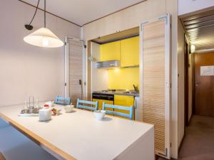 普雷圣迪迪埃Apartment Universo-1 by Interhome的厨房以及带白色桌椅的用餐室。