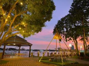 曼谷Montien Riverside Hotel Bangkok的晚间带桌椅的凉亭