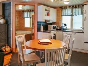 鲁卡Holiday Home Rukan pramea by Interhome的厨房以及带木桌和椅子的用餐室。