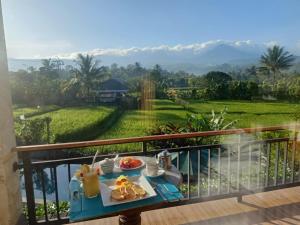 MayongThe Aroma Villa Munduk的阳台上的桌子和食物托盘