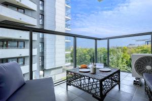 华沙Wola Luxury Stay的阳台配有桌子,享有建筑的景致。