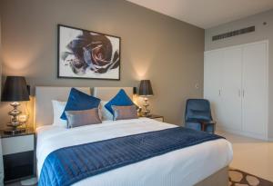 迪拜Premium Studio with Beautiful Golf Course View的一间卧室配有一张大床和一张蓝色椅子