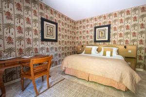 尼约勒拉夏贝尔圣马丁酒店的一间卧室配有一张床、一张书桌和壁纸