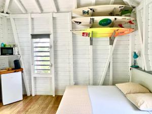 德赛Le Surf Lodge, chambre avec vue mer dans un écrin de verdure的墙上挂着冲浪板的房间
