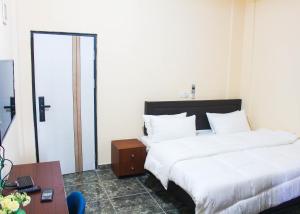 阿克拉High Level Apartment的酒店客房设有两张床和一张桌子。