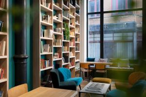 布鲁塞尔阿利斯大酒店的图书馆设有书架和桌椅