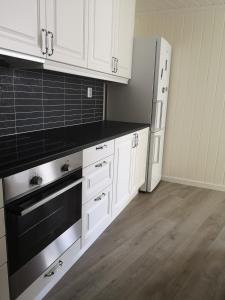 哈尔登New 2 bed room apartment in Halden的厨房配有白色橱柜和黑色用具