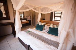 奥考奎约托夏瑞旅舍的一间卧室配有一张带蓝色枕头的天蓬床