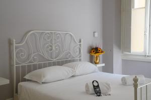 佛罗伦萨Affittacamere ALBA的白色的床,配有银色床头板和白色枕头
