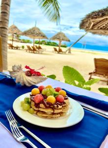 蓬圭Karibu Beach Resort的海滩上桌上的水果松饼