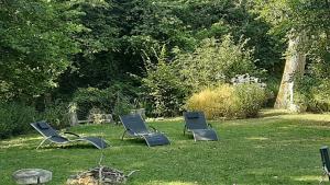 Saint-Aubin-sur-GaillonLODGE EXTERIEUR 2 PERSONNES (possibilité toile de tente en plus pour efants avec futon)的坐在院子里的草地上的三把椅子