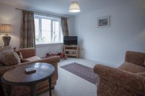 纳伯斯Maes Yr Odyn - 3 Bedroom Holiday Home - Narberth的带沙发、桌子和电视的客厅