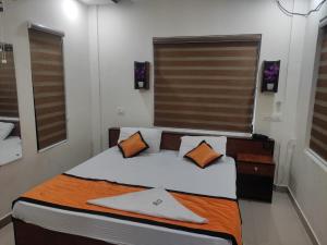 KottakkalPMS Dhabi Residency的一间小卧室,配有带橙色枕头的床