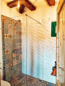 BerteaLa sat - Mândră Ioană的浴室设有马赛克墙和淋浴。