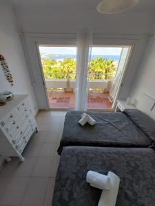 圣埃乌拉利亚Siesta Mar Apartamentos Ibiza的一间卧室设有一张大床和一个大窗户