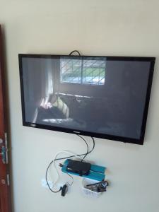 雅帕拉廷加Casas Aconchego do Mar的挂在墙上的平板电视,带视频游戏控制器