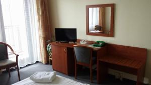 布拉格克里斯塔尔酒店的客房设有一张带电视和镜子的书桌