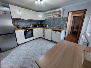 阿拉德Cozy, quiet & family friendly in Arad的厨房配有白色橱柜和木桌