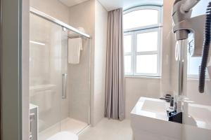 里斯本Hotel MeraPrime Gold Lisboa的带淋浴和盥洗盆的白色浴室