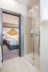里斯本Hotel MeraPrime Gold Lisboa的带淋浴的浴室和卧室