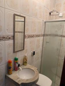 蒂拉登特斯Hostel Lumiar da Serra的浴室配有盥洗盆和带镜子的淋浴