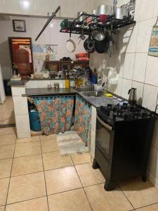 蒂拉登特斯Hostel Lumiar da Serra的厨房配有水槽和炉灶 顶部烤箱