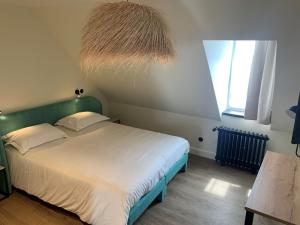 勒帕莱Grand Hôtel de Bretagne的一间卧室配有一张带绿色床头板的床