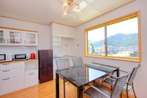 富士吉田市赤富士亭的厨房配有桌椅和窗户。