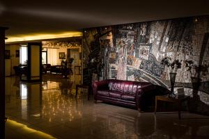 普罗夫迪夫圣彼特堡公园酒店的大堂的真皮沙发,配有大型壁画