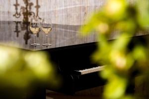 普罗夫迪夫圣彼特堡公园酒店的钢琴上坐着两杯白葡萄酒