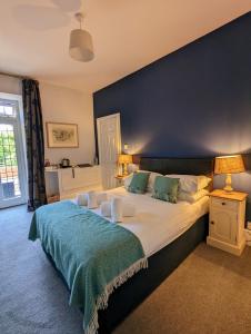 Martinhoe猎人酒店的一间卧室设有一张蓝色墙壁的大床