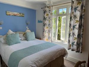 尚克林Bedford Lodge的一间卧室配有一张蓝色墙壁的床和一扇窗户