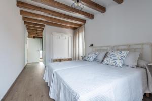 伊扎洛Casa de Miranda的白色卧室配有白色床和蓝色枕头