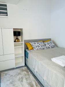 鲍洛通维拉戈什ARIS Apartman的一间白色卧室,配有一张床和一个梳妆台
