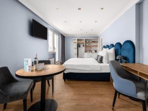 杜塞尔多夫numa I Artol Rooms & Apartments的酒店客房带一张床、一张桌子和椅子