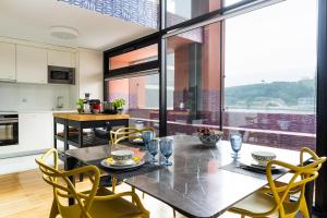 波尔图Porto Insight Apartment River View - Pool & Garage的厨房以及带桌椅的用餐室。