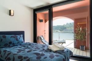 波尔图Porto Insight Apartment River View - Pool & Garage的一间卧室配有一张床,享有水景